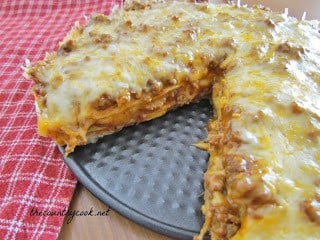 A close up of a slice of pizza on a paper plate, with Taco