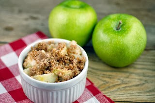 A bowl of fruit sitting on a table, with Apple and Crisp