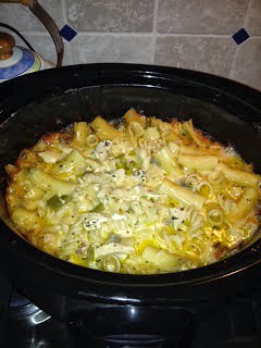 A bowl of food cooking on a stove, with Chicken and Pasta