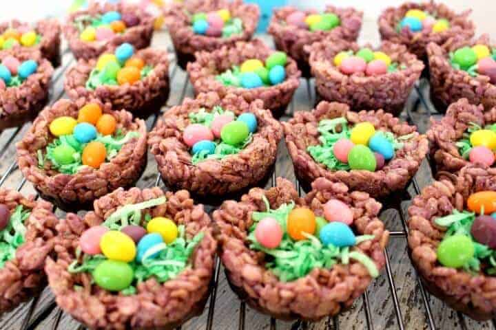 Chocolate rice crispy treats in the shape of a nest filled with Easter eggs