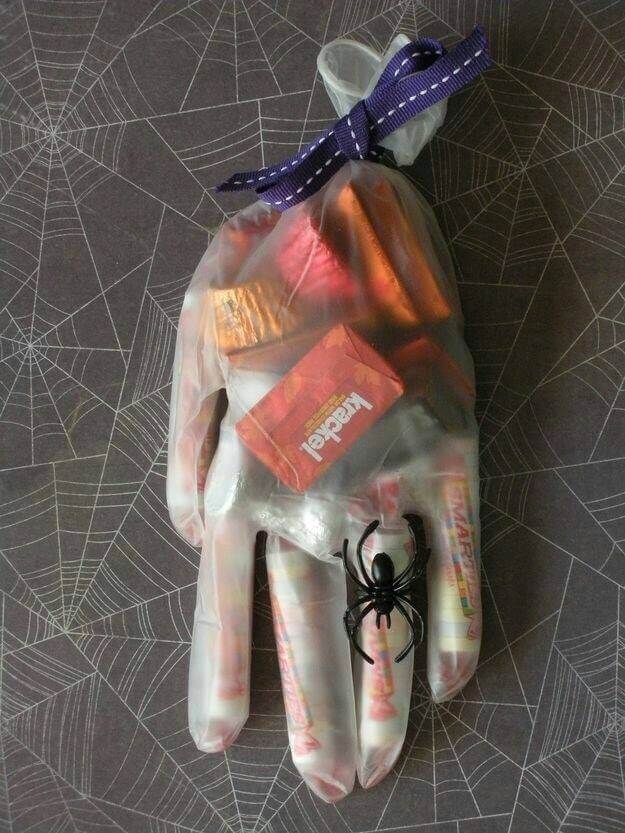 A rubber glove filled with candy with a spider on the ring finger