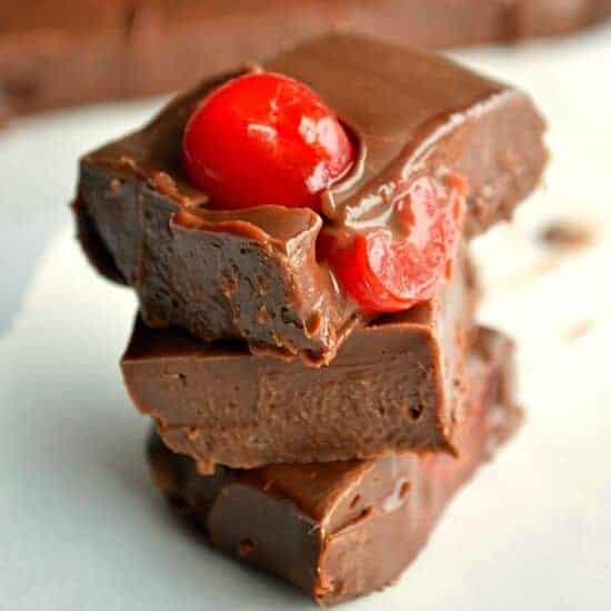 A piece of chocolate cake on a plate, with Cherry and Fudge