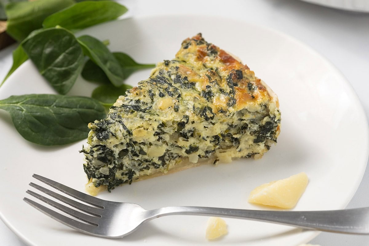 a slice of spinach pie on a plate. 