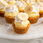 Mini banana cream pies topped with banana slices and whipped cream.