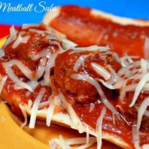 A close up of a plate of food with a slice of pizza, with Meatball