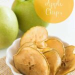 Caramel apple chips in a white bowl with green apples in the background