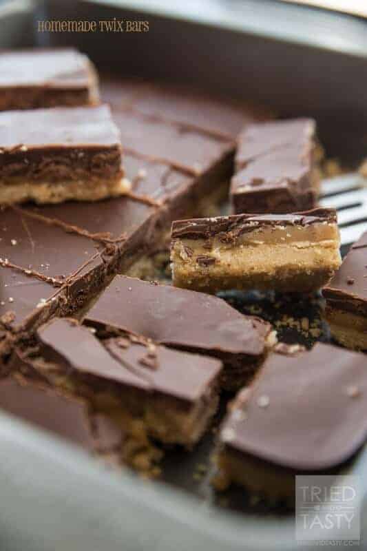 A piece of chocolate cake on a plate, with Twix and Chocolate chip