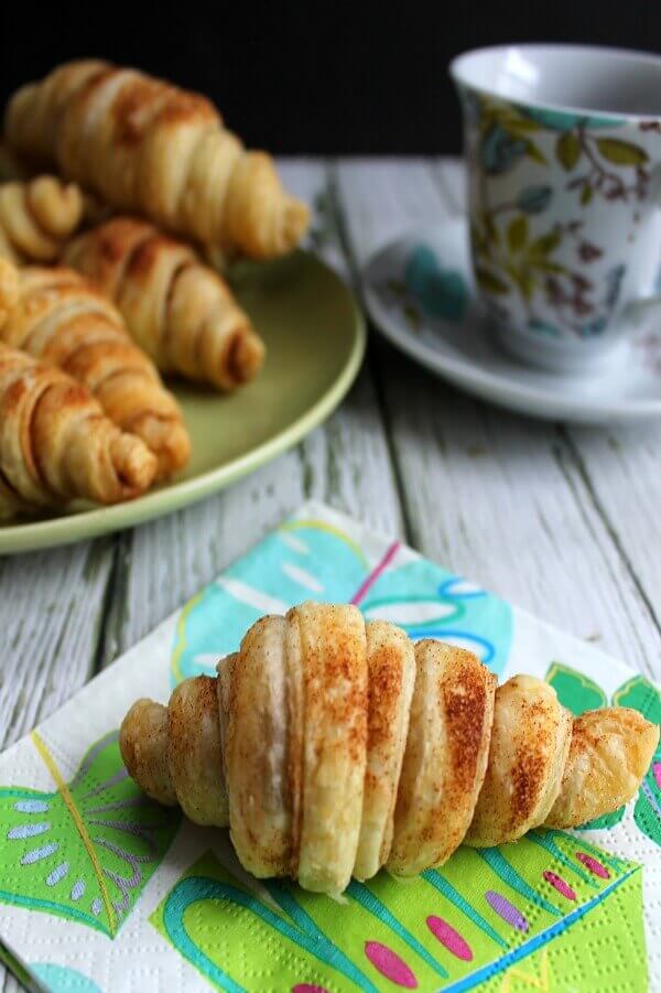 A plate of food and a cup of coffee, with Cinnamon and Croissant