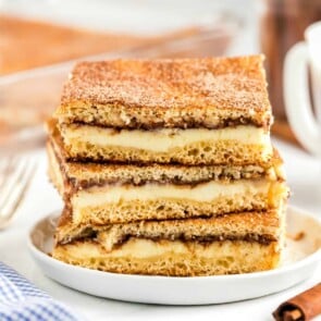 Sopapilla Cheesecake bars stacked on a plate.