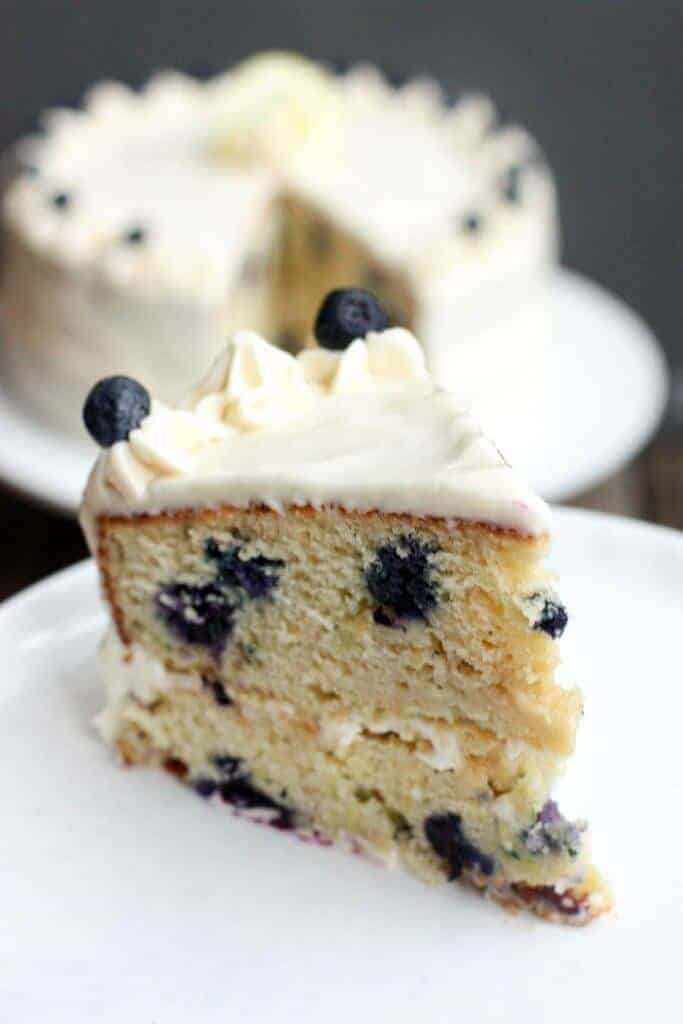 A close up of a slice of cake on a plate, with Blueberry and Cream cheese