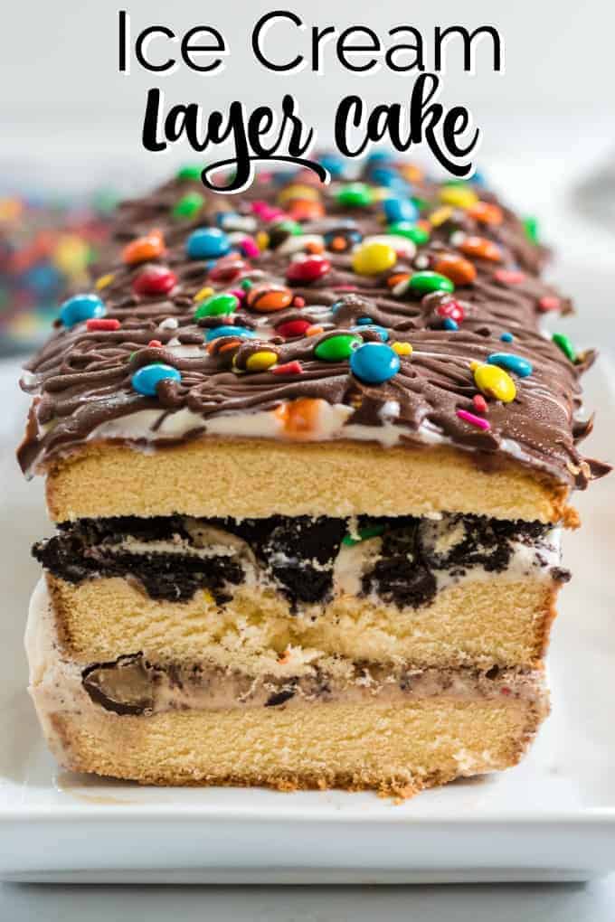 A layered ice cream cake with chocolate on top and M&Ms