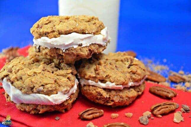 Oatmeal cream cookies with walnuts and a glass of milk and a red plate