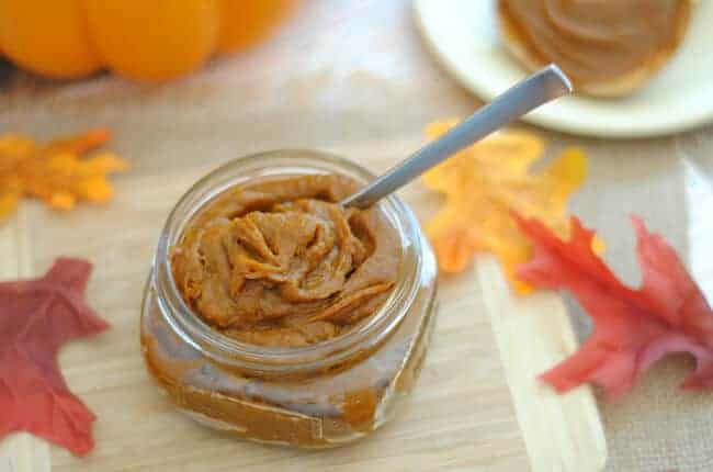 Pumpkin butter on a wood table with leaves