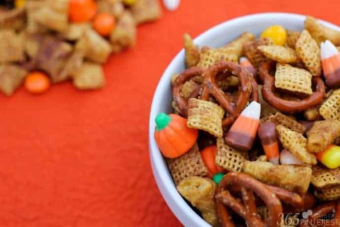 Pumpkin Spice Snack Mix in a white bowl on an orange table cloth