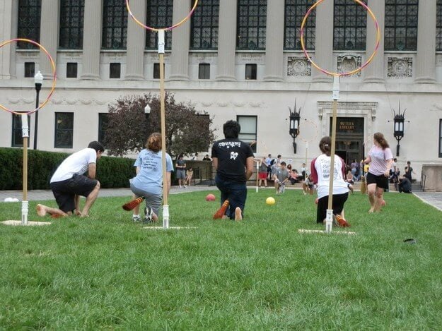 A group of people playing frisbee in a yard