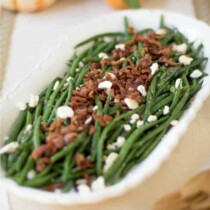 A bowl with green beans bacon and feta cheese