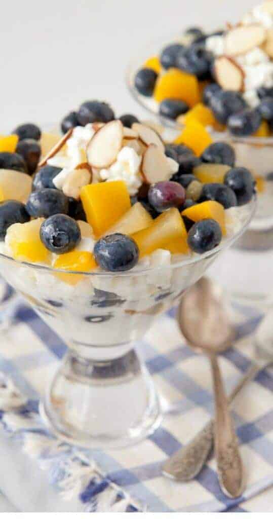 A bowl of fruit on a plate, with Blueberry and Parfait