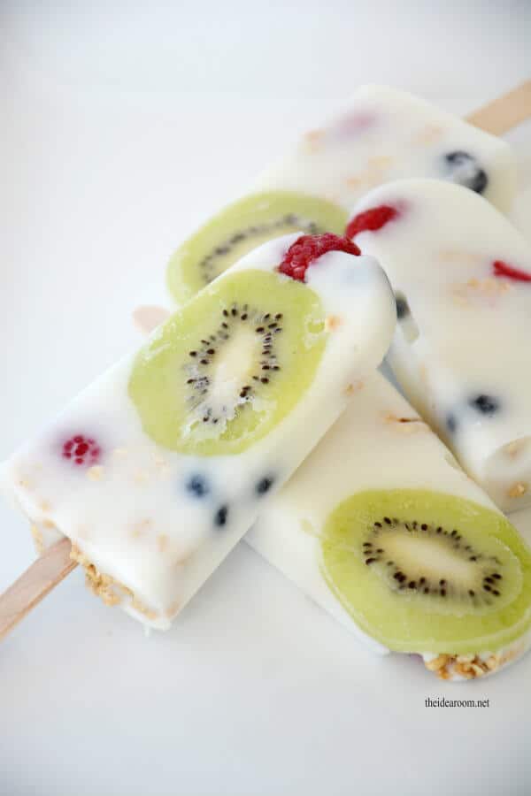 Popsicles made out of yogurt with fruit in them including kiwi and raspberries