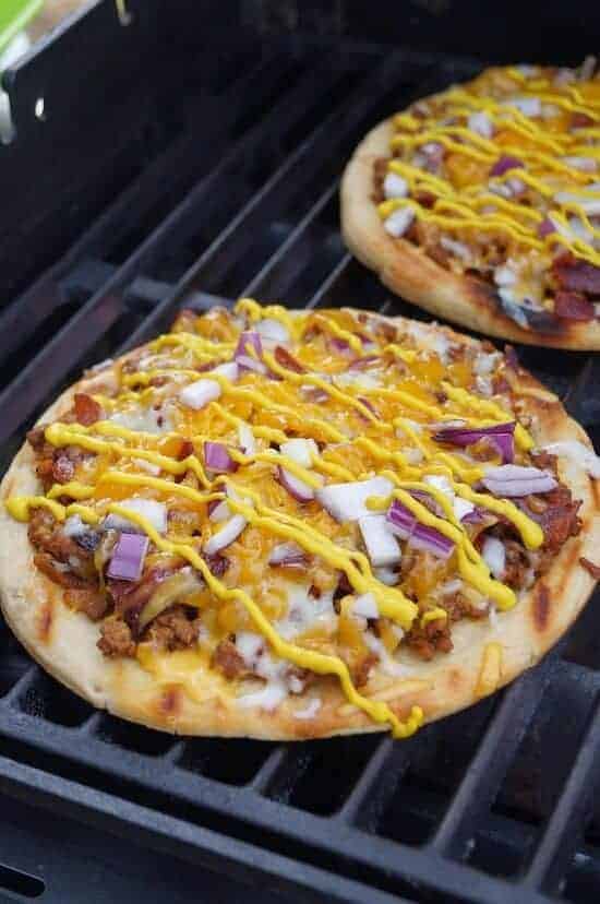 A pizza sitting on top of a pan on a stove top oven, with Grilling and Cheeseburger