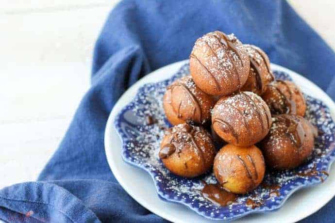 Deep friend cookie dough sprinkled with powdered sugar and drizzled with chocolate