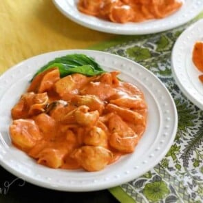 A bowl of food on a plate, with Chicken and Pasta