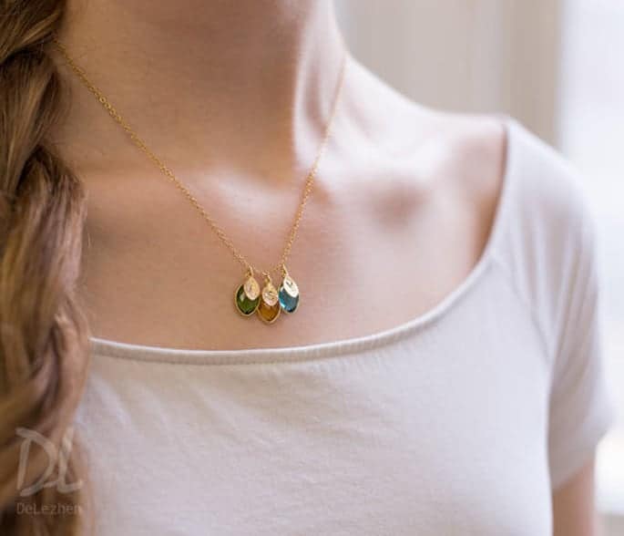 A close-up of an initial and birthstone necklace