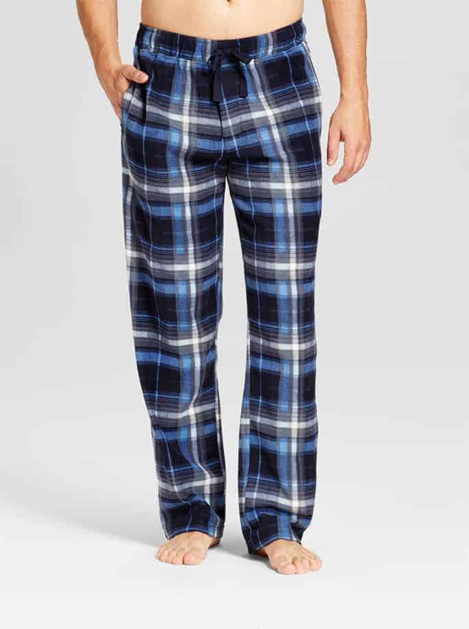 A person from the waist down wearing men\'s pajama pants