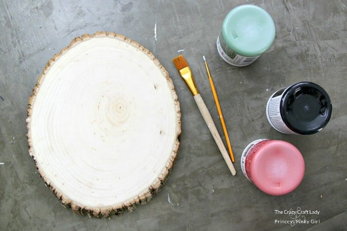 Materials needed to make a Wood Slice Painted Wreath - chalkboard paint, paint brushes and a wood round