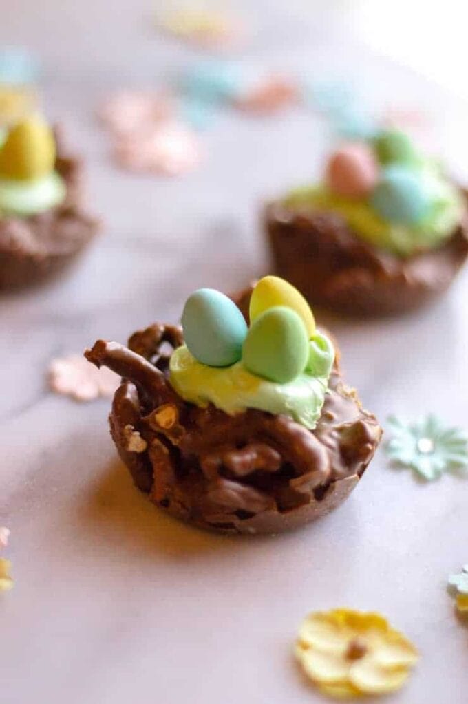A chocolate treat with frosting and candy eggs to look like an easter nest