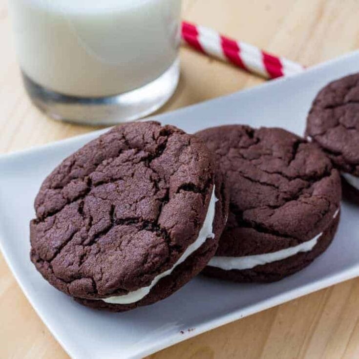 Homemade Oreo cakes and a white plate with a glass of milk