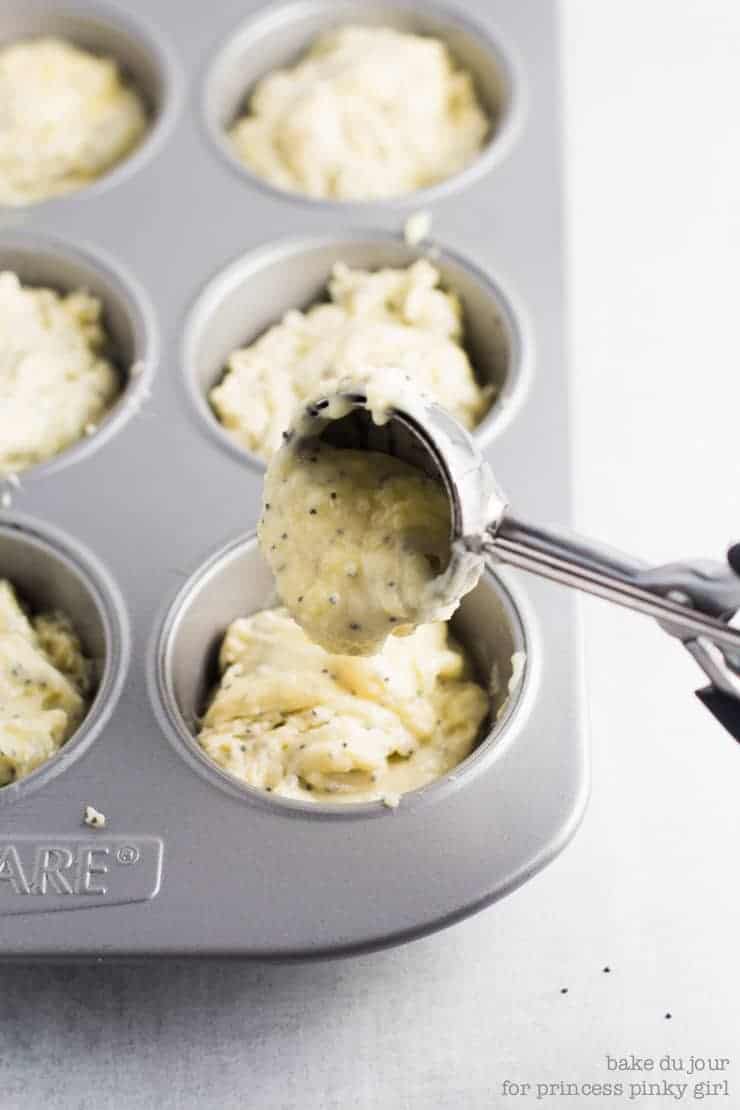 A scoop of batter going in a muffin tin