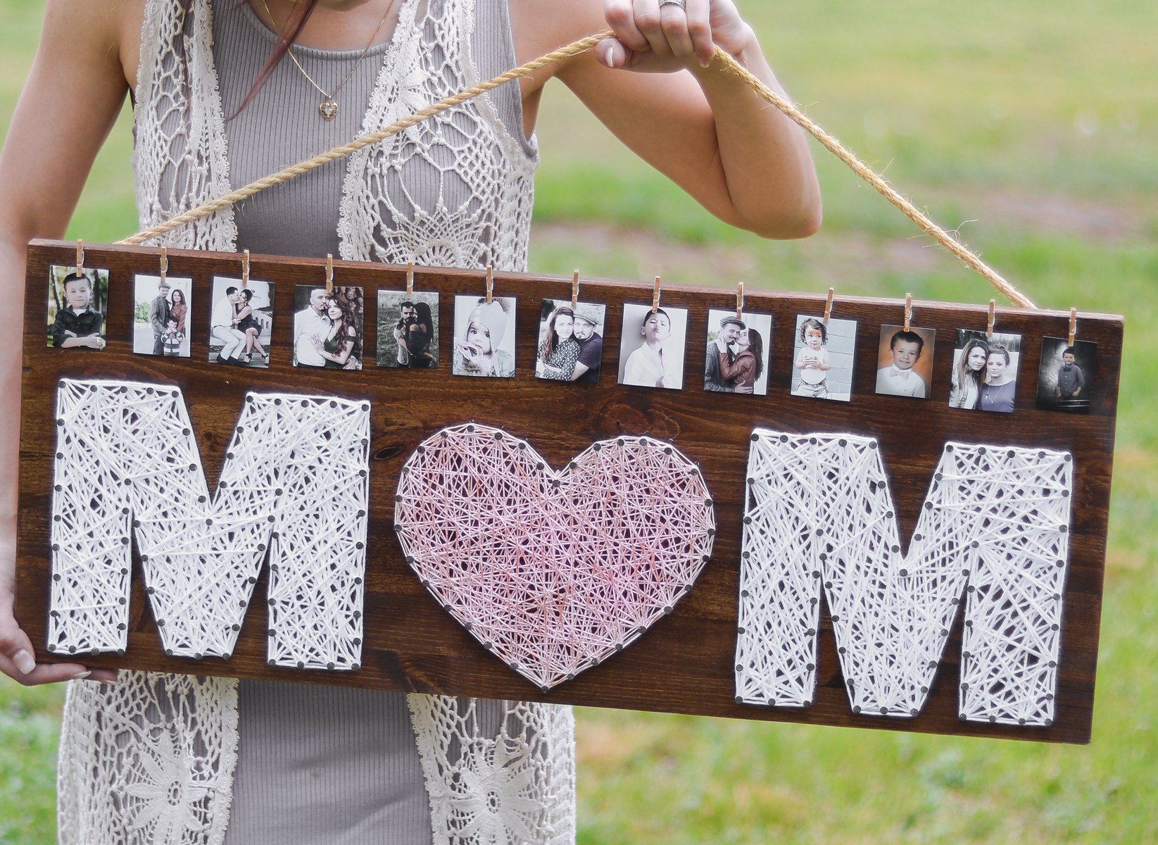 A string art photo frame for a Mother\'s Day gift being held by a string