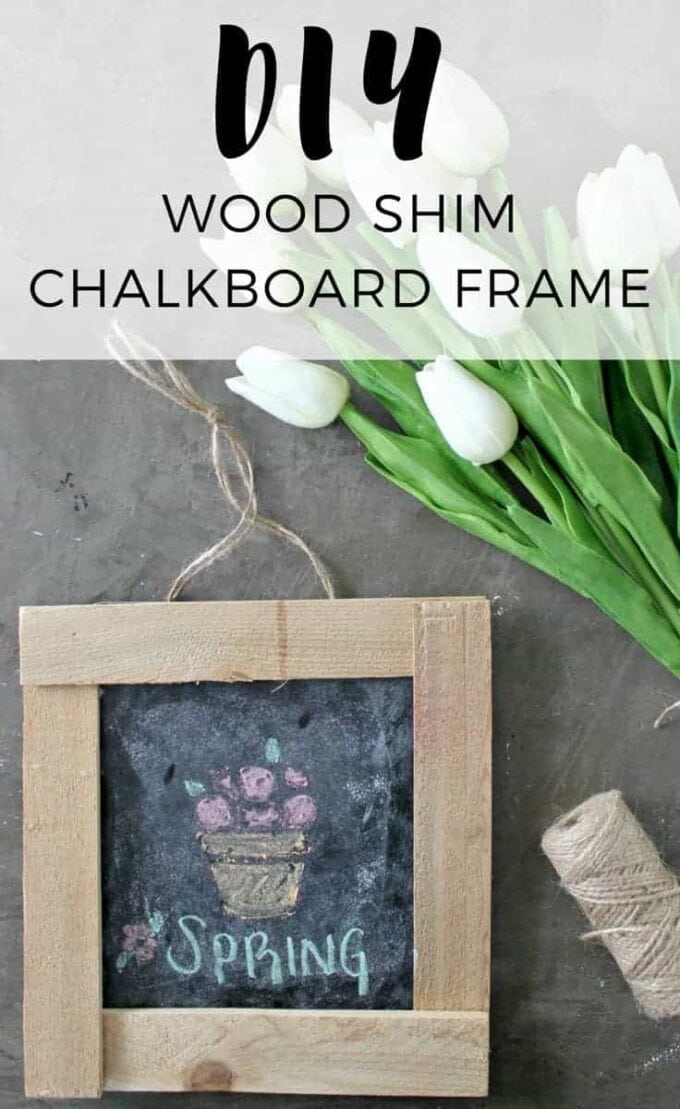 A close-up of a chalk board frame with flowers in the background.