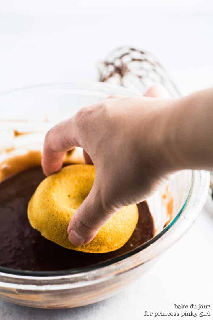 Dipping the vanilla doughnut in a bowl of chocolate glaze
