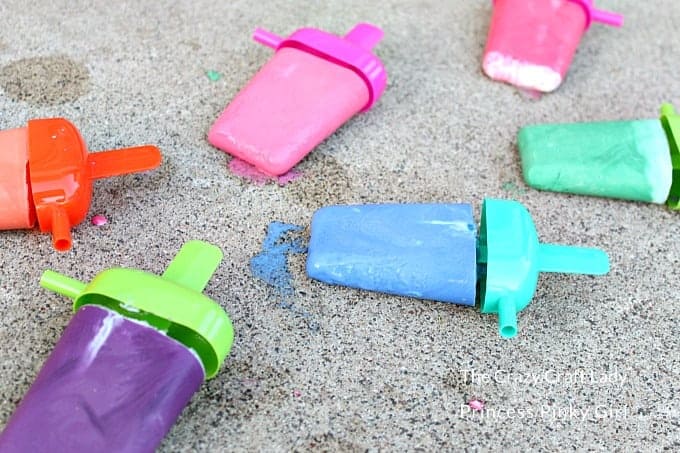 Sidewalk chalk in the shape of popsicle molds on a driveway