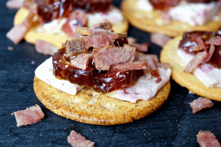 Cranberry bacon date cracker stacks on a black plate