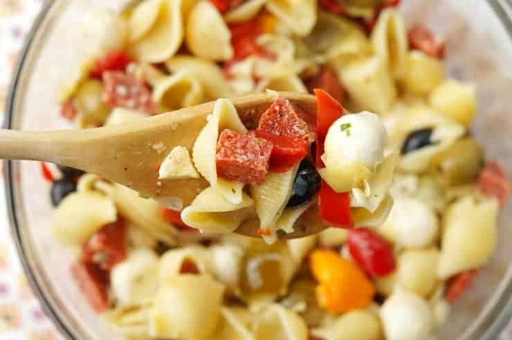 Antipasto pasta salad and a wooden spoon