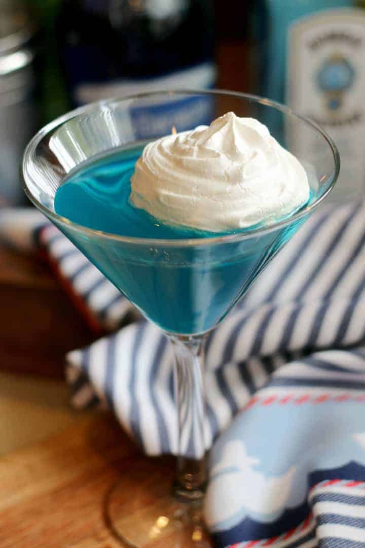 A blue martini with meringue cookie on top
