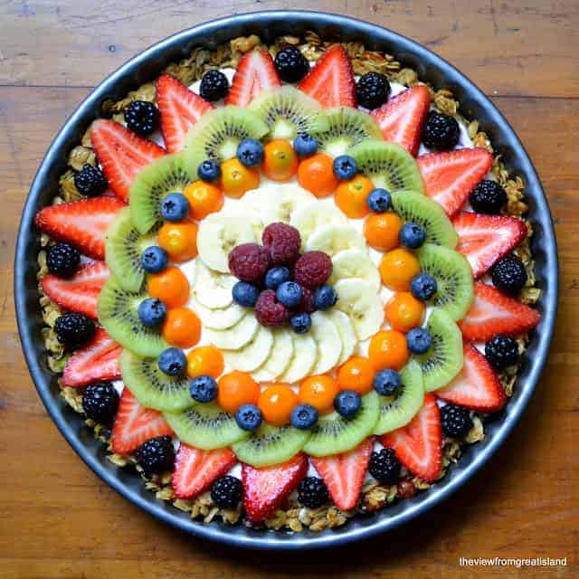 A breakfast fruit tart with strawberries kiwi blueberries raspberries and bananas