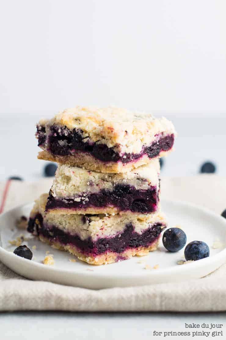 Blueberry Crumble Bars - a stack of 3 Blueberry Crumb Bars on a white dish