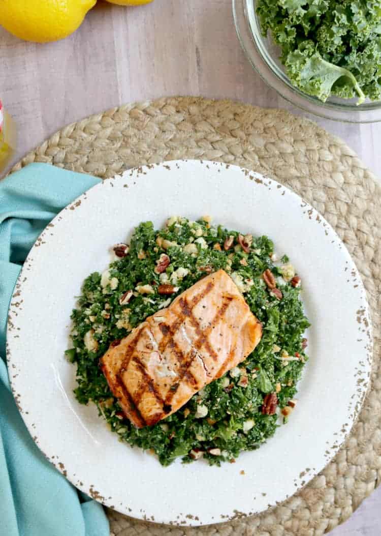 grilled salmon with kale salad on a plate. 