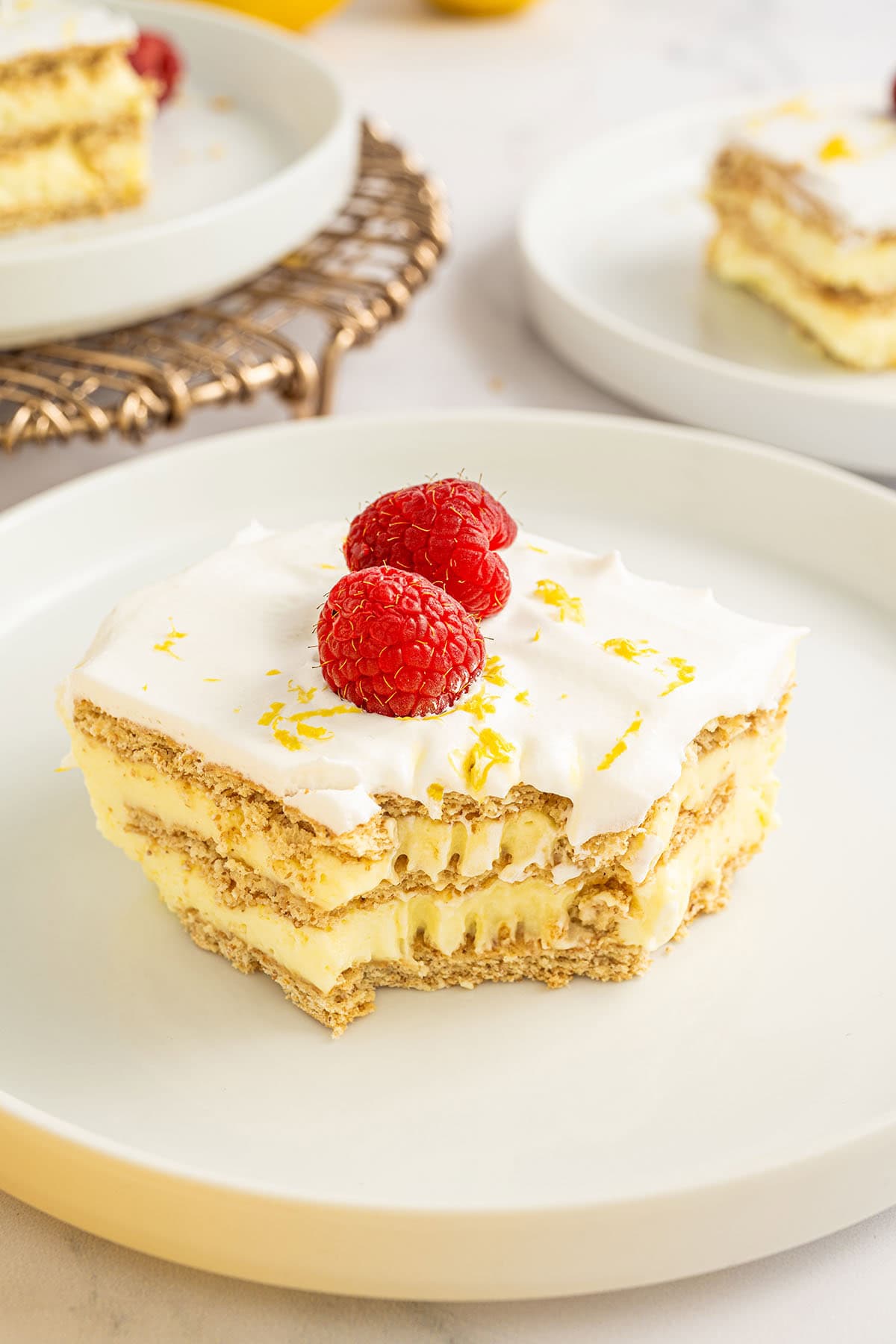 Slice of lemon icebox cake with raspberries on top.