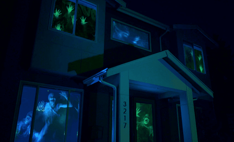 A picture of a house with scary Halloween characters in windows