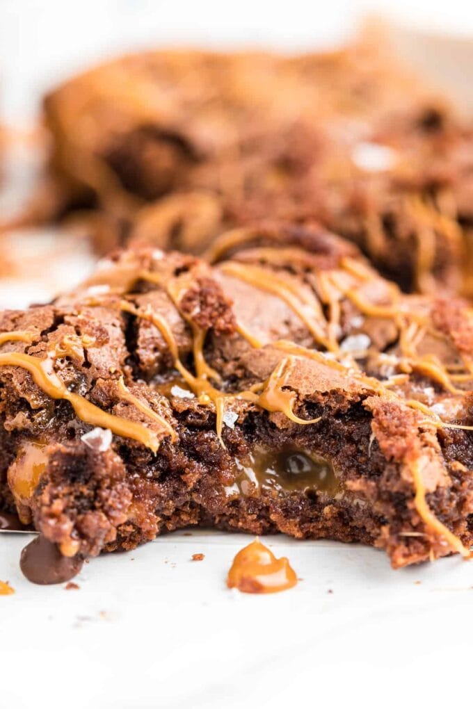close up of salted caramel brownies with a bite