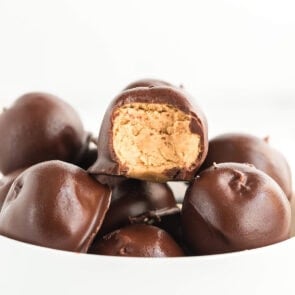 a couple of peanut butter balls in a white bowl.