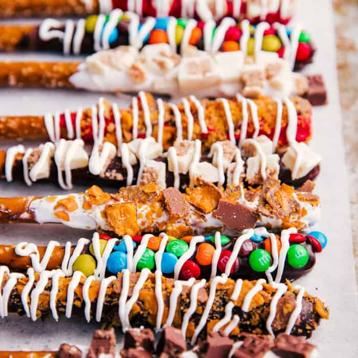chocolate covered pretzel rods coated with candy toppings.
