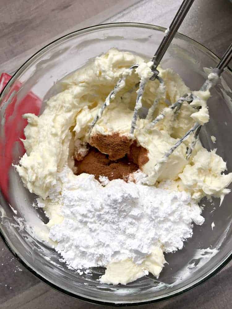mixing ingredients together with a hand mixer in a glass bowl