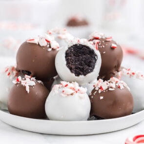 Peppermint Oreo Truffles stacked on top of a white plate.