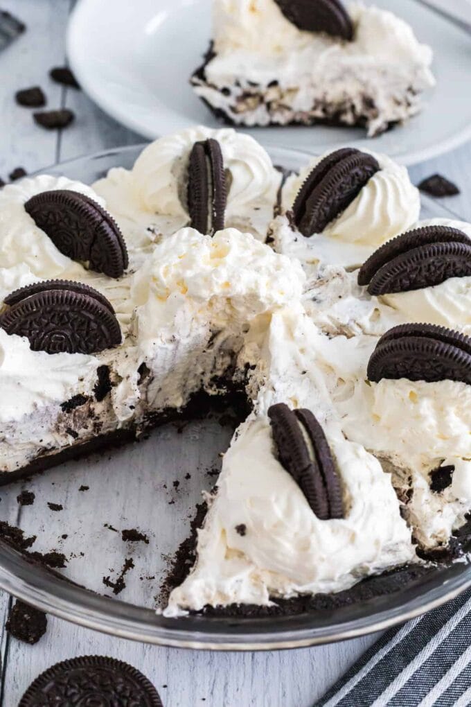 Oreo Pie with piece out and Oreos on top with whipped cream