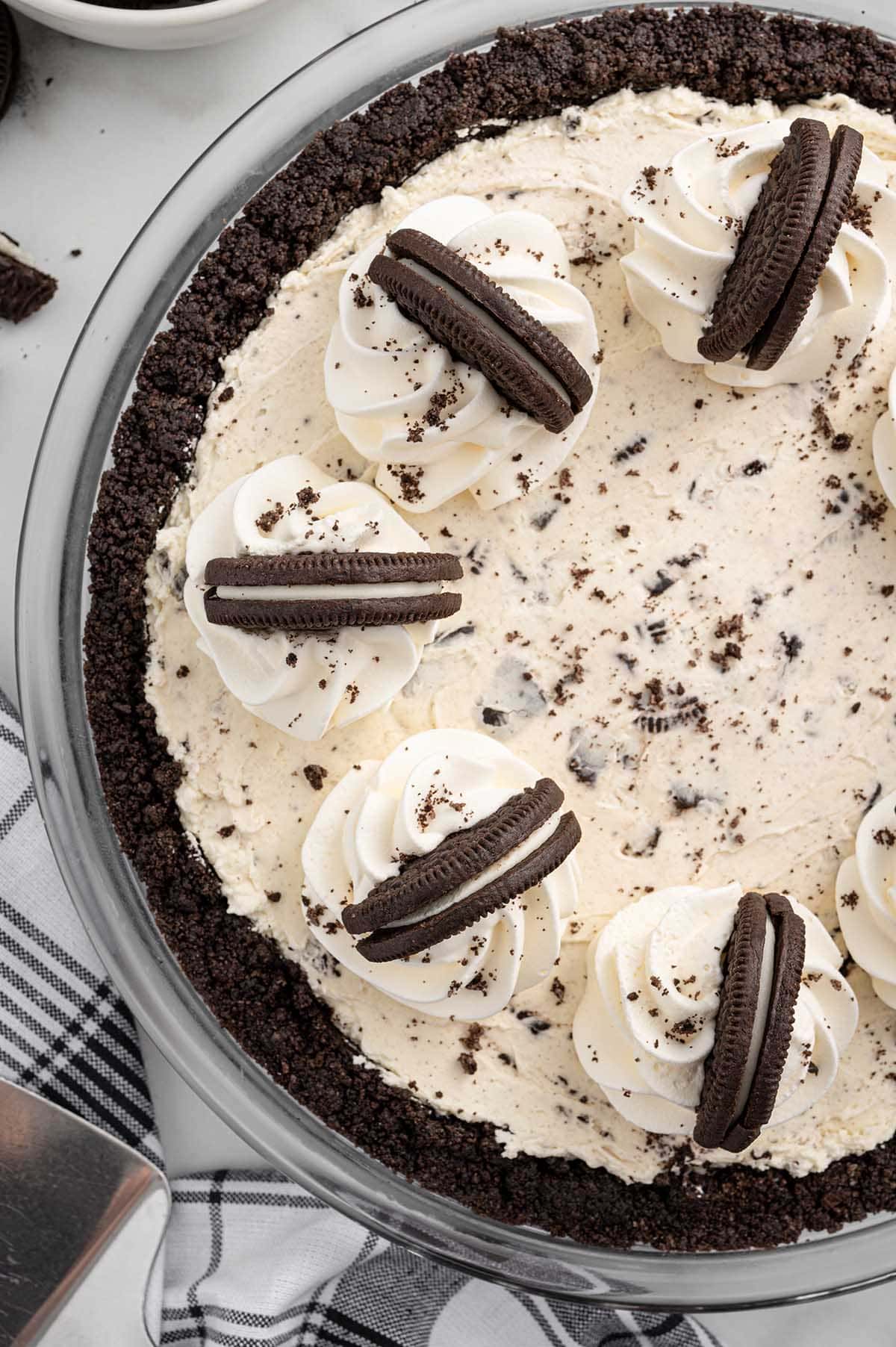 Overhead view of No Bake Oreo Pie topped with whipped cream swirls and Oreo cookie halves in a chocolate cookie crust.